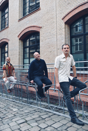 Rezound Band Picture as trio standing near a bike stand